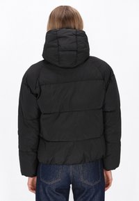 Sort dunjakke med quiltet design, justerbar hætte og elastiske manchetter. Bagfra ses en cropped silhuet og glat tekstur.