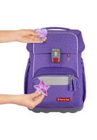 Lila Rucksack mit grauen Akzenten, ausgestattet mit einem Punktmuster, verstellbaren Trägern, einer Fronttasche und abnehmbaren Stern- und Herz-Abzeichen.