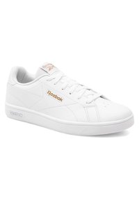 Adidași albi din piele, cu o textură netedă, vârf rotund și design cu șireturi. Prezintă un logo subtil Reebok aurit pe lateral și pe limbă.