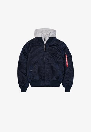 Marine bomberjack met een grijze capuchon sweatshirt binnenin, ritszakken, geribbelde manchetten en een rode "Remove Before Flight" tag op de mouwzak.