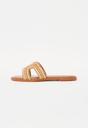 Sandale à glisser avec une semelle marron et un large dessus présentant des motifs entrecroisés en orange et or. Design plat et ouvert à l'avant.