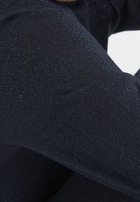 Tmavě modrá texturovaná tkanina, s jemn�ými světelnými skvrnami, úzce oříznutá, aby ukázala vazbu a lesk, s hladkým povrchem.