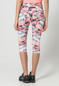 Legginsy capri wykonane z elastycznego materiału, z różowo-niebieskim geometrycznym wzorem, z talią o średnim wzroście i szwami płaskimi.