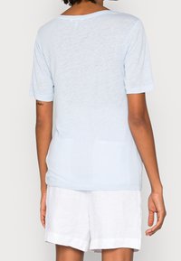 Vaaleansininen, lyhythihainen t-paita rentoa istuvuutta ja pyöreää kaula-aukkoa. Valmistettu pehmeästä, teksturoidusta materiaalista. Näyttää sujuvan selkäprofiilin.