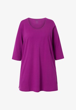 Paarse, kortärmad tuniek met een ronde hals, gemaakt van zacht materiaal. Heeft zijsplitten voor een relaxte fit. Zachte textuur zonder patronen.