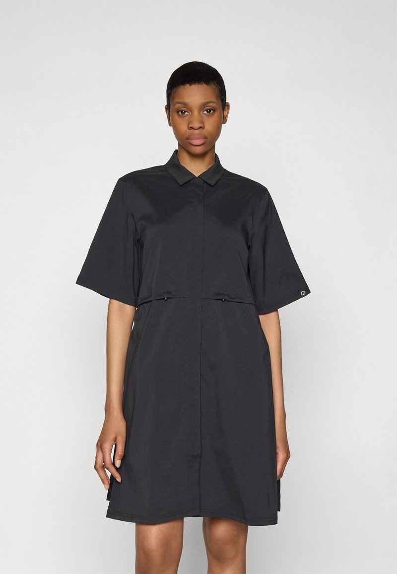 Abito nero in tessuto morbido, con colletto a camicia, maniche corte e vita cinchata con piccoli lacci sul davanti.