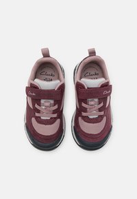 Para dziecięcych sneakersów w kolorze bordowym i szarym, z zapięciem na rzepy i uchwytami, widoczna z góry na białym tle.
