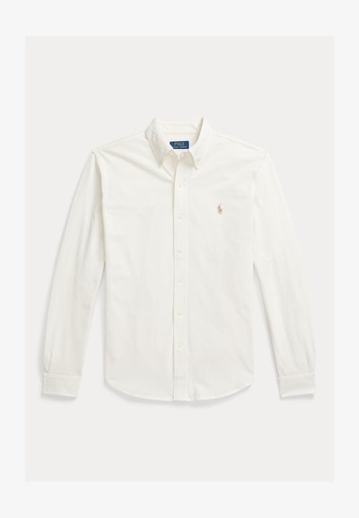 Valge pikakäeline nööbitav särk kraega ja Polo Ralph Laureni logo vasakul rinnal tikitud.