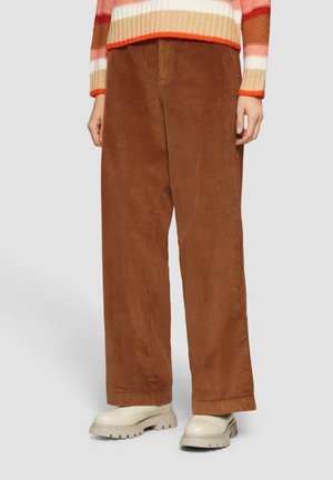Bruine corduroy wijde broek heeft een gestructureerd oppervlak, een hoge taille, zijzakken en is gecombineerd met chunky crèmekleurige schoenen.