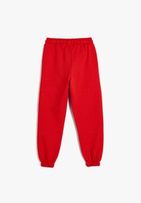 Pantalones de chándal rojos con cinturilla elástica y puños fruncidos. Fabricados en tela suave, presentan un diseño simple y sin adornos.