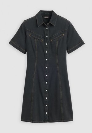Zwarte denim jurk met korte mouwen, met een knoopsluiting aan de voorkant, twee borstzakken met gele ritsen en contrasterende stiksels.