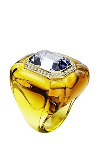 Gul hartsmycke med en stor, rektangulär, klar ädelsten och mindre vita accentstenar i guld runt den övre kanten, smidigt formad.