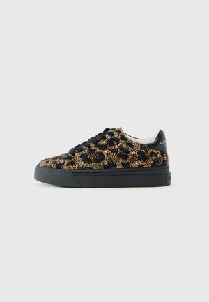 Sneaker a basse con suola nera, lacci neri e motivo leopardo realizzato con piccoli chiodi d'oro e neri sulla parte superiore.