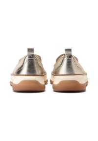 Beiga slip-on sneakers med metalliska guldaccenter, textilöverdel, rundad design och gummisula med en ljusbrun botten.