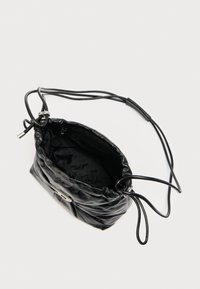 Sort læderpose med snor, blød tekstur, sølvbeslag og indvendigt med et mærkelogo. Har en slank rem.