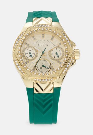 Gulltone klokke med en teksturert grønn silikonreim. Har en rund urskive, flere subskiver og en bezel med krystallinnslag.