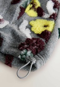 Gray fabric with textured, colorful floral patterns in yellow, white, burgundy, and green. Features a gray drawstring toggle for adjustment.