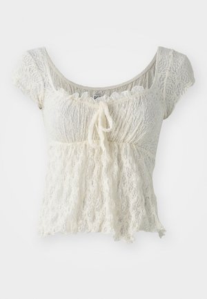 Weißes Spitzen-Crop-Top mit kurzen Ärmeln, strukturiertem Stoff, gerafftem Bund und einer Bindeschleife vorne, mit einem gewellten Ausschnitt.