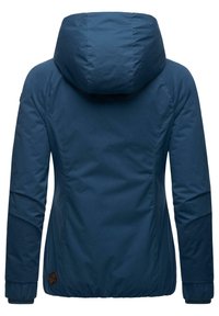 Navyblauwe hoodie met een gladde textuur, verstelbare manchetten en een lichte rimpeling bij de taille. Heeft een logo-embleem aan de zijkant.