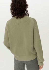 Stickad tröja i olivgrön, med en avslappnad passform och ribbat avslut. Texturerad tyg med en mysig, stretchbar design.