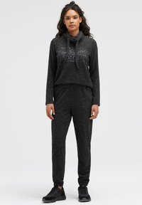 Dunkelgrauer, weicher Stoff-Loungewear-Set mit einem lockeren Hoodie mit Fronttasche und passenden Jogginghosen mit elastischen Bündchen.
