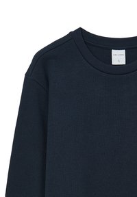 Navyblaue, strukturierte Langarmbluse mit rundem Ausschnitt und gerippten Akzenten. Das Etikett ist sichtbar und zeigt die Größe L von Calliope.