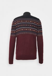 Bordeauxroter und schwarzer Strickpullover mit hohem Kragen, der horizontale, mehrfarbige geometrische Muster auf dem oberen Rücken und den Schultern zeigt.