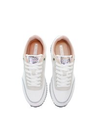 Białe i beżowe sneakersy z metalicznymi akcentami, z sznurowanym designem, gumową podeszwą i miękkim teksturowanym materiałem. Wewnątrz widoczna metka marki.