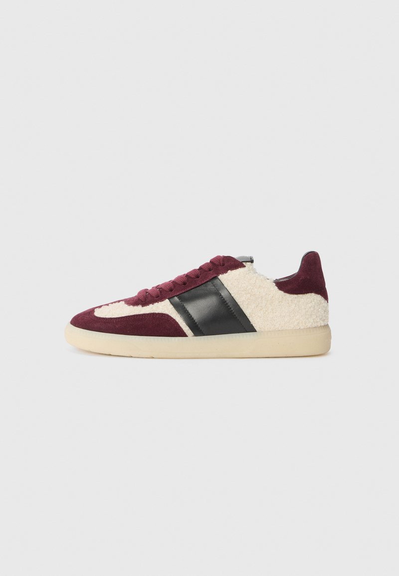 Baskets avec une tige en daim bordeaux, des côtés texturés crème, des accents en cuir noir et une semelle en caoutchouc beige. Elles présentent des lacets ronds et un profil bas.