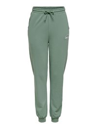 Pantalon de survêtement vert en mélange de coton avec taille �élastique, cordon de serrage, poches latérales et poignets côtelés. Comprend un logo blanc sur le devant.