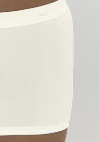 Boxer shorts de algodón blanco con elastano y una cinturilla suave que presenta un discreto logo, mostrando una superficie suave y texturizada.