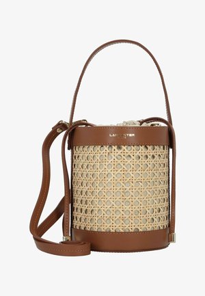 Sac seau avec un corps en rotin naturel tressé, des accents en cuir marron et une bandoulière réglable. Il présente un sommet à cordon de serrage et un marquage doré.