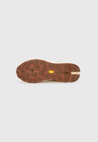 Brown rubber sole with multidirectional tread pattern; features a yellow accent and light-colored tread for enhanced grip.