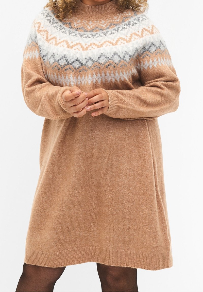 Robe en tricot beige avec un empiècement en motifs gris clair et blanc. Manches longues, col rond et coupe décontractée. Texture douce, longueur genou.