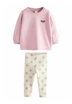 Różowy bawełniany sweatshirt z haftem motyla; połączony z kremowymi legginsami z kwiatowym wzorem i skomplikowanymi detalami w kropki.