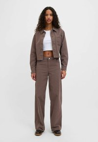 Brown and white striped cropped jacket with matching wide-leg pants. Material has a soft texture. Features a chest pocket and button closure.