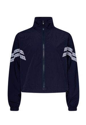 Marineblauw vestje met ritssluiting, hoge kraag en twee witte kanten strepen op elke mouw, elastische manchetten en een iets cropped pasvorm.