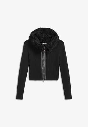 Black cropped jacket featuring ribbed fabric and a fuzzy collar. It has a front zipper and long sleeves, with a smooth leather accent down the center.