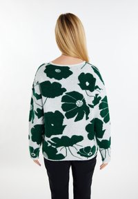 Gebreide trui met een grijze achtergrond en grote donkergroene bloemenpatronen, lange mouwen en een losse, ontspannen pasvorm.