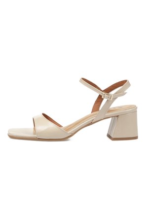 Sandalia beige con punta abierta, tacón bloque bajo y correa ajustable en el tobillo con cierre de hebilla.