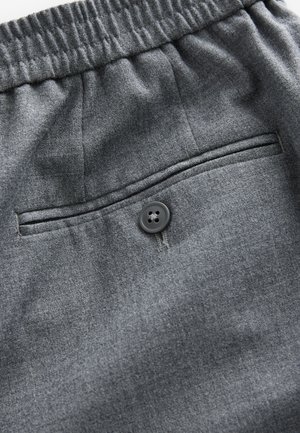 Graue Stoffshorts mit einem elastischen Bund, einer Gesäßtasche mit schwarzem Knopf und einer glatten, strukturierten Oberfläche.