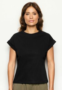 Sort t-shirt med korte ærmer i en afslappet pasform, rund halsudskæring og oprullede ærmer, lavet af glat stof.