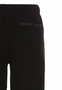 Sorte sweatpants med en blød tekstur, der har en elastisk talje og en lille baglomme med knaplukning.