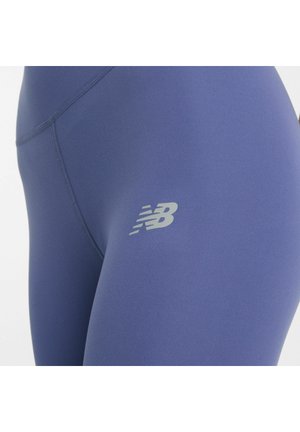Leggings van diepblauwe stof met een gladde textuur, voorzien van een reflecterende grijze logo op de dij en platte naden voor extra comfort.