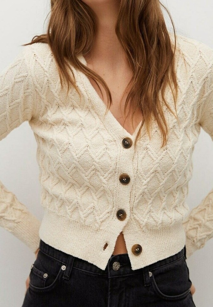Pull en tricot crème avec un motif en diamant, doté d'un col en V, de cinq boutons marron et d'une taille ajustée.