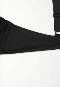 Černý bikiny top z látky s texturovaným designem, který má široký pás a nastavitelné ramínka pro bezpečné uchycení.