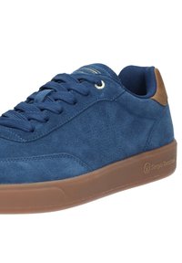 Sneaker in suede blu navy con punta rotonda, dettagli marroni, occhietti dorati e una suola in gomma testurizzata che presenta un logo sul lato.