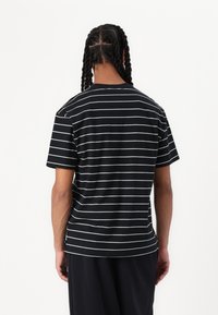 Schwarz-weiße gestreifte Kurzarm-T-Shirt mit lockerer Passform, aus weichem Baumwollstoff, sichtbaren Nähten und geradem Saum.