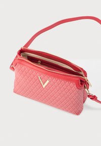 Borsa a mano rossa con motivo decorativo, logo in metallo dorato, doppia chiusura con zip e tracolla regolabile lunga, caratterizzata da una texture liscia e un design compatto.