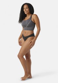 Reggiseno sportivo atletico nero con motivo grigio testurizzato e spalline doppie, abbinato a uno slip bikini nero a vita alta. Tessuto liscio, design aderente.